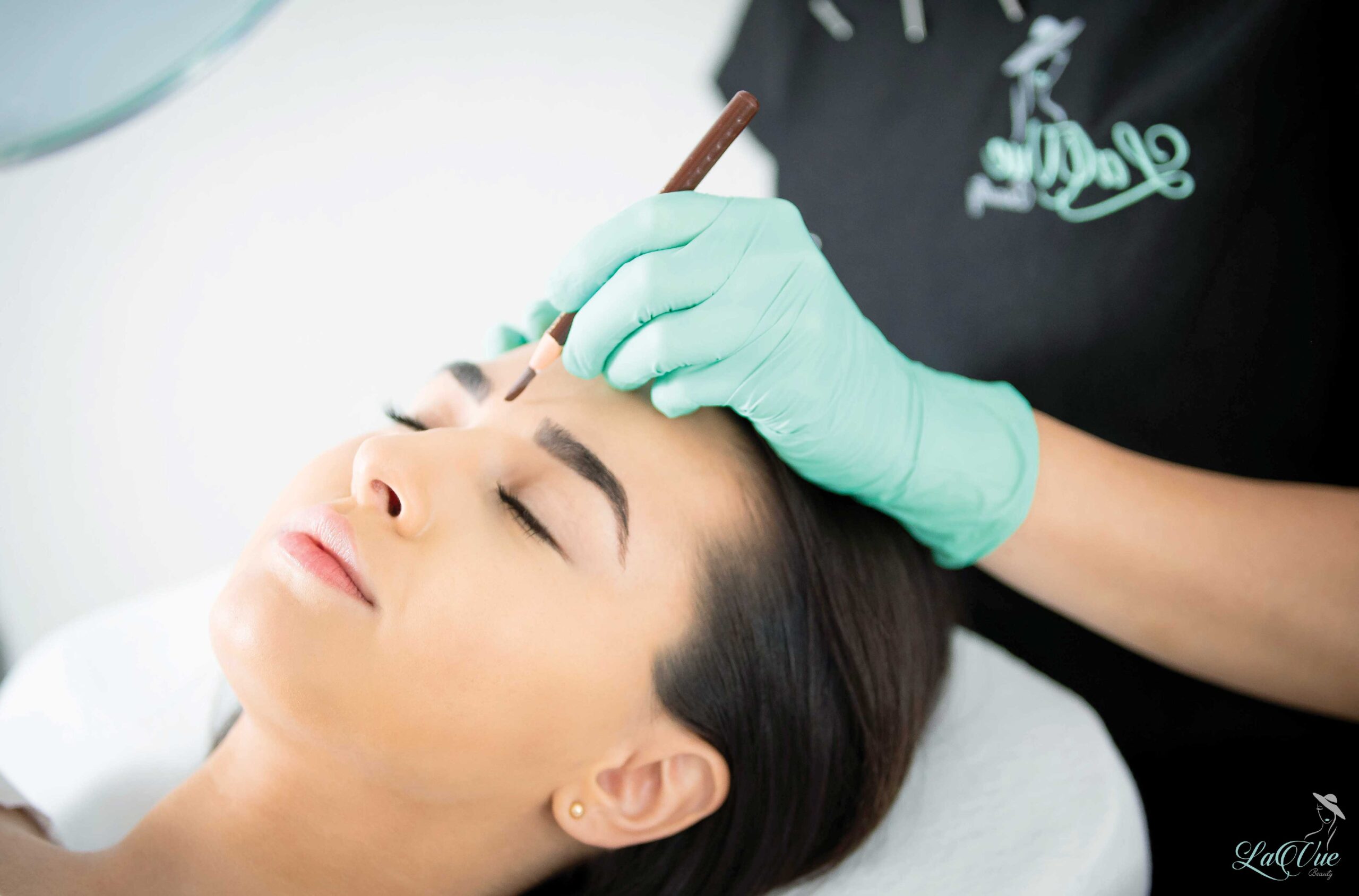 lavuebeauty artist Danijela Atanasovska bei der Vorzeichnung für die PMU Behandlung der Augenpartie bei einer lächelnden Kundin, die entspannt ihre Augen geschlossen hat