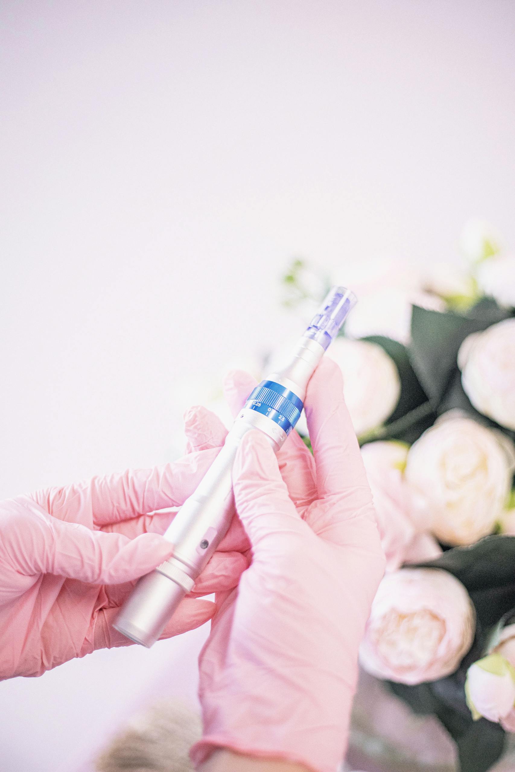 Close-up of hands holding a micro-needling pen, highlighting its use in modern aesthetic treatments.